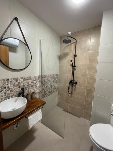 a bathroom with a shower and a sink and a mirror at Апартамент Стил in Chepelare