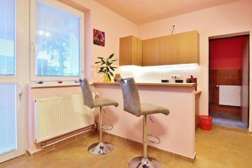 a kitchen with two bar stools in front of a counter at NIKA beds in Pardubice
