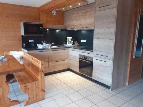 a kitchen with wooden cabinets and a stove top oven at Les Adrets in Gérardmer