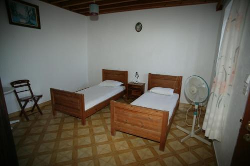 a room with two beds and a fan in it at Eugenia villa in Lindos