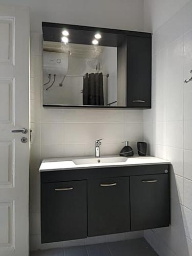 a bathroom with a sink and a mirror at Hermes Penthouse in Ermoupoli