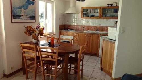 - une cuisine avec une table et des chaises en bois ainsi qu'un évier dans l'établissement Maison Andro, à Locmaria