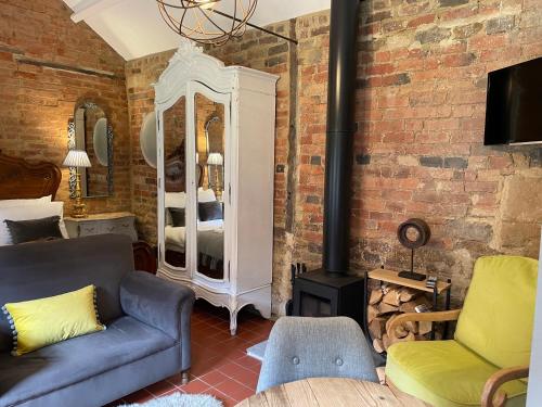ein Wohnzimmer mit einem Sofa und einem Kamin in der Unterkunft Topiary Barn - Stylish Accommodation in Rutland in Uppingham