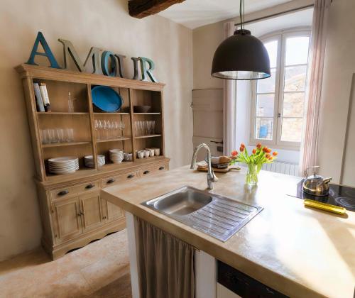 uma cozinha com um lavatório e uma bancada em Luxurious Provencal Village House, Walk to Village Pool em Rustrel