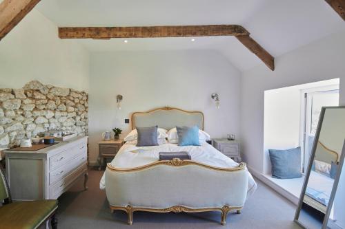 a bedroom with a large bed and a stone wall at Luxurious property set in the heart of Cornwall with breathtaking views -Rhubarb Cottage in Helston