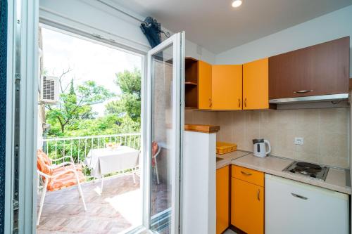 a kitchen with a sliding glass door leading to a balcony at Apartment & Rooms Papa in Mlini