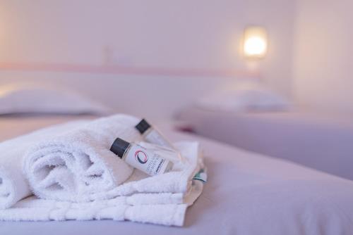 a pile of towels sitting on top of a bed at The Originals City, Relax'Otel & Spa, Le Barcarès in Le Barcarès