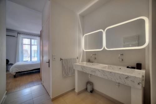 a white bathroom with a sink and a mirror at Superbe 3 pieces Moderne et tres Central A2B233 in Cannes