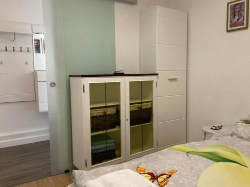 a bedroom with a glass cabinet with a butterfly on it at Jarmila Vendégház in Balatonberény