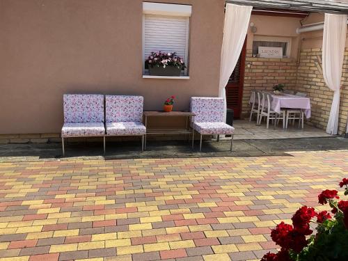 a patio with two chairs and a table with flowers at Jarmila Vendégház in Balatonberény