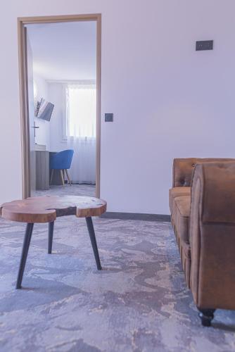 a living room with a table and a couch at The Originals City, Relax'Otel & Spa, Le Barcarès in Le Barcarès