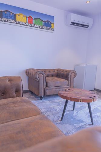 a living room with a couch and a table at The Originals City, Relax'Otel & Spa, Le Barcarès in Le Barcarès