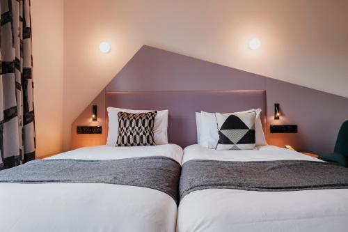 two beds sitting next to each other in a bedroom at The Fox & Goose Hotel in London