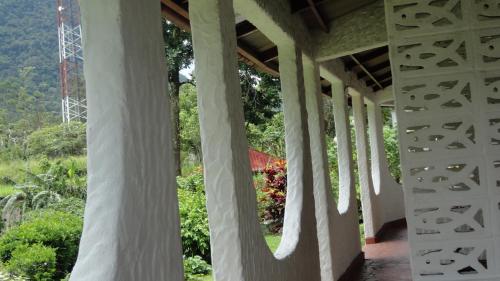 a building with white columns and trees in the background at Hotel Valle Verde in Valle de Anton