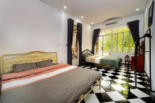 a bedroom with two beds and a checkered floor at Nhà đầy nắng homestay in Nha Trang