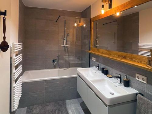 a bathroom with a sink and a shower and a tub at Alpenblick Apartment in Tauplitz