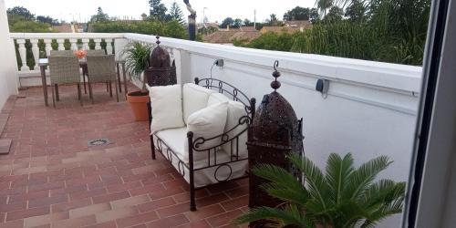 een balkon met een stoel op een patio bij Room in Lovely cottage house Habitaciones en Chalet en Cadiz San Fernando in San Fernando