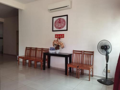 a dining room with a table and chairs and a fan at 马六甲热带果园度假屋 in Malacca
