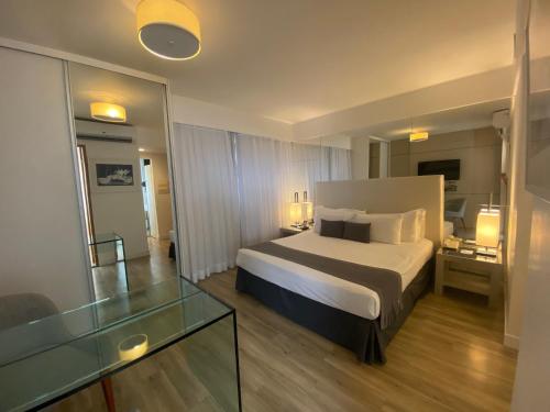 a hotel room with a bed and a glass table at H2 Platinum Lourdes in Belo Horizonte
