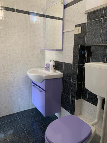 a bathroom with a white toilet and a sink at Favignana: La porta sul mare in Favignana