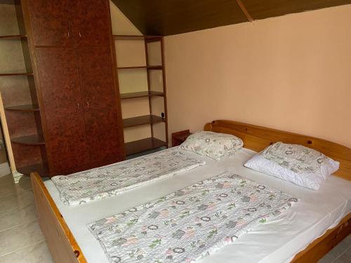 2 camas individuales en un dormitorio con estanterías en Töreki 34 Vendégház, en Siófok