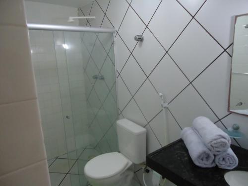 uma casa de banho com chuveiro, WC e toalhas em Marinas de Tamandaré 102 em Tamandaré