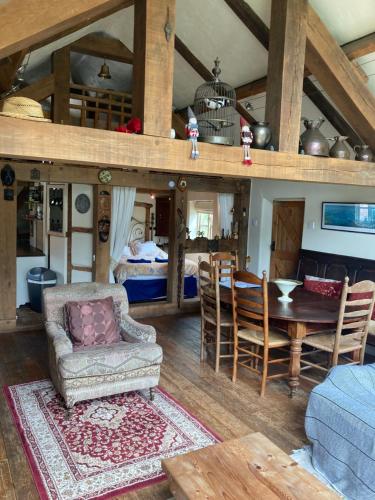 a living room with a table and a dining room at Little Pentre Barn with cozy logburner in Wrexham
