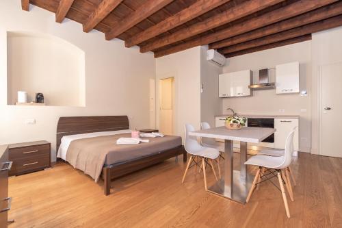 1 dormitorio con 1 cama, mesa y sillas en PALAZZETTO IL MANGANO - F&L Apartment en Brescia
