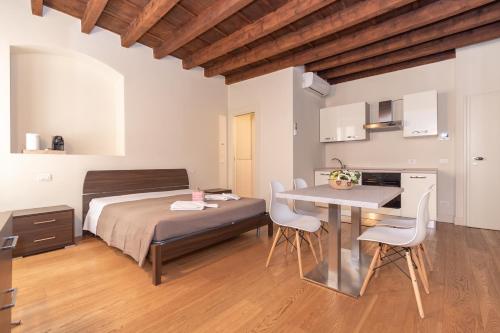 a bedroom with a bed and a table and chairs at PALAZZETTO IL MANGANO - F&L Apartment in Brescia