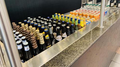 un mucchio di bottiglie di vino su una mensola di Totalenergies Frit Autentic Habay-la-Neuve a Habay-la-Neuve
