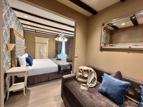 威尼斯Cà Dell'Arte Palace的一间酒店房间，里面有一张床和一张沙发