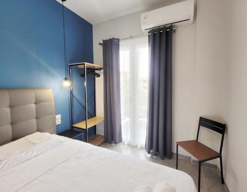 ein Schlafzimmer mit einem Bett, einem Stuhl und einem Fenster in der Unterkunft LA CASA DE PROFESOR 1 in Kalambaka