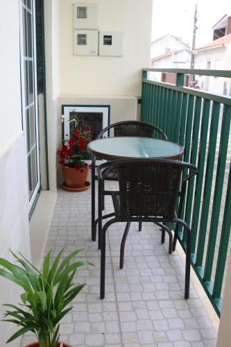 eine Terrasse mit einem Tisch und Stühlen auf dem Balkon in der Unterkunft Nazaré Holidays in Nazaré
