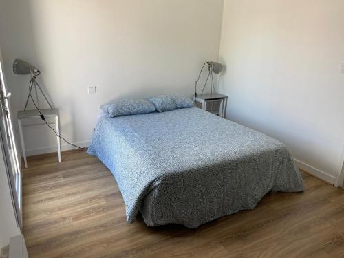 une chambre avec un lit avec une couverture bleue dans l'établissement Centre-ville au calme grand T2 avec terrasse, à La Rochelle