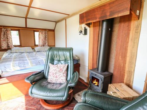 a living room with a chair and a stove at Hawthorn Hut in Llanidloes