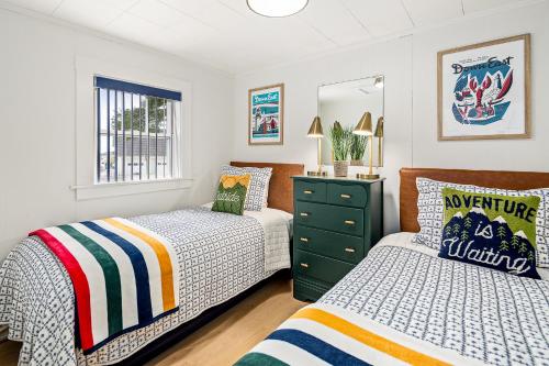 a bedroom with two beds and a dresser at Seascape Motel & Cottages in Belfast
