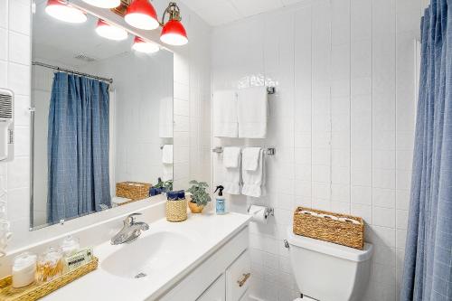 a bathroom with a sink and a toilet and a mirror at Seascape Motel & Cottages in Belfast
