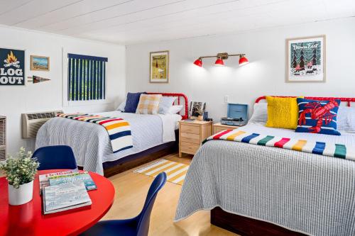 a bedroom with two beds and a table and chairs at Seascape Motel & Cottages in Belfast