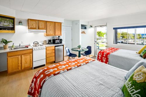 a room with two beds and a kitchen with a sink at Seascape Motel & Cottages in Belfast