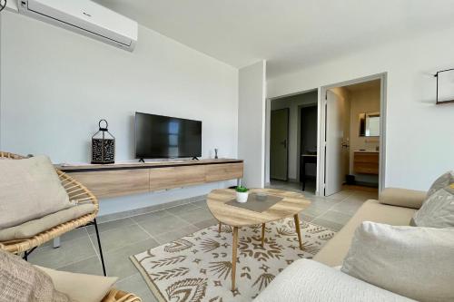 a living room with a couch and a tv at Mereani flat brand new condo in the center of Papeete in Papeete