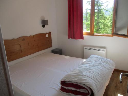 - une chambre avec un lit et une fenêtre dans l'établissement Appartement T3 neuf au frais à la montagne, à Puy-Saint-Vincent