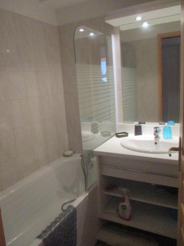 La salle de bains est pourvue d'une baignoire, d'un lavabo et d'une baignoire. dans l'établissement Appartement T3 neuf au frais à la montagne, à Puy-Saint-Vincent
