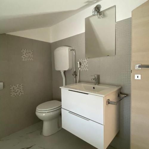 a bathroom with a toilet and a sink and a mirror at Valle Caterina in Torino di Sangro