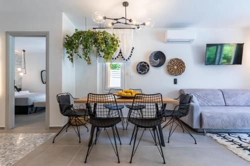 AGNONTAS LUXURY VILLAS في Agnontas: مطبخ وغرفة معيشة مع طاولة وكراسي