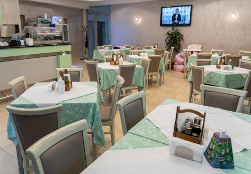 a dining room with tables and chairs and a tv at Hotel Salida in Prilep