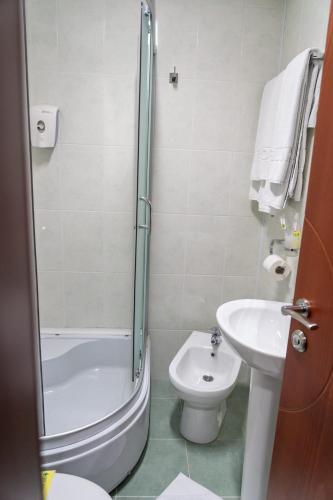 a bathroom with a shower and a toilet and a sink at Hotel Salida in Prilep