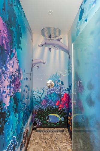 La salle de bains est pourvue d'une fresque murale représentant un aquarium. dans l'établissement KER MANOU - Baie des dauphins, à Cancale