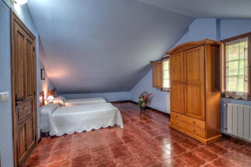 a bedroom with a white bed and a wooden cabinet at Posada de Ajo in Ajo
