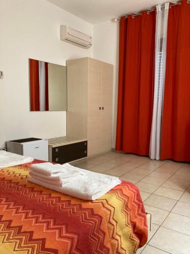 una camera con letto e tenda rossa di Solìa Bed & Breakfast a Scalea