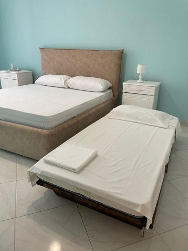 two beds sitting next to each other in a bedroom at DANTE APARTAMENT in Vlorë